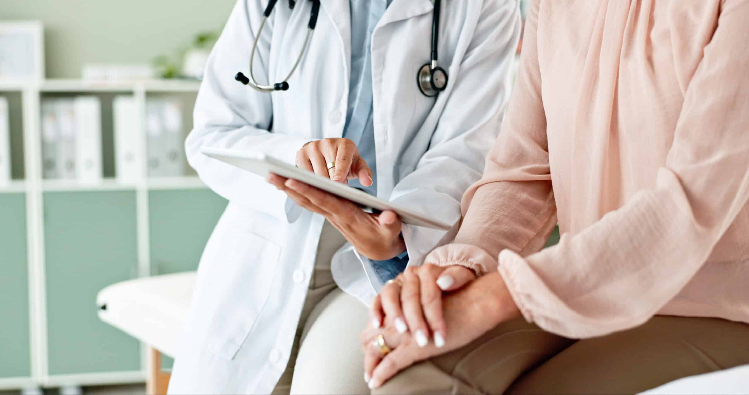 Clinic, tablet and hands of doctor with patient for consulting, medical service and help in hospital. Healthcare, telehealth and people on digital tech for diagnosis, online results and insurance.